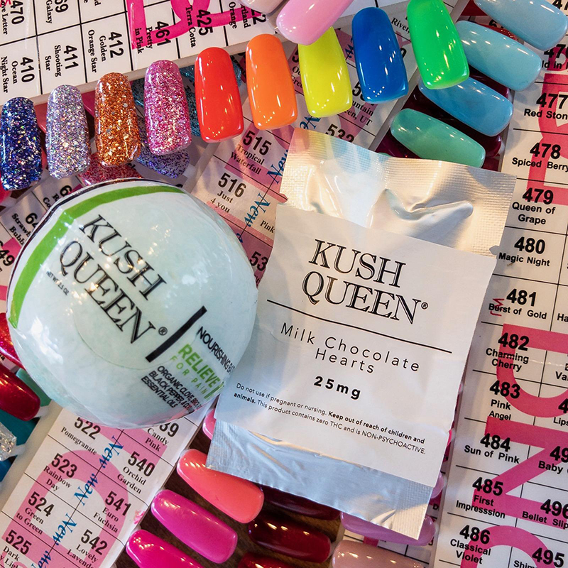 Mini 10mg CBD Relieve bath bomb and 25mg Chocolate Heart by Kush Queen laying atop acrylic nail designs.